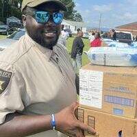 Darlington County Sheriff’s Office officer assists with transporting supplies during the back-to-school drive thru and youth summit held on Friday, July 14th in Hartsville, SC.