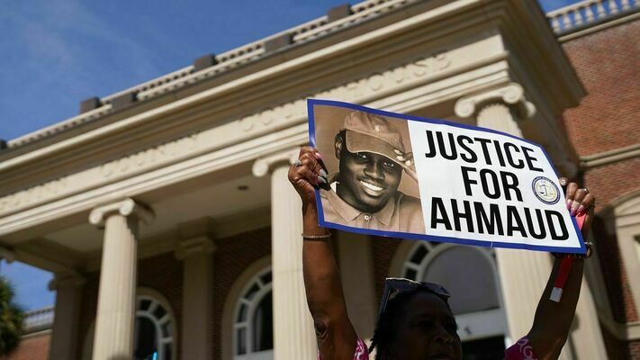 Protestor holds a sign calling for justice for Ahmaud Arbery outside of the Glynn County Courthouse.